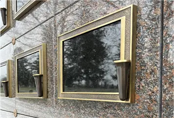 A bronze niche plaque with an integrated flower vase
