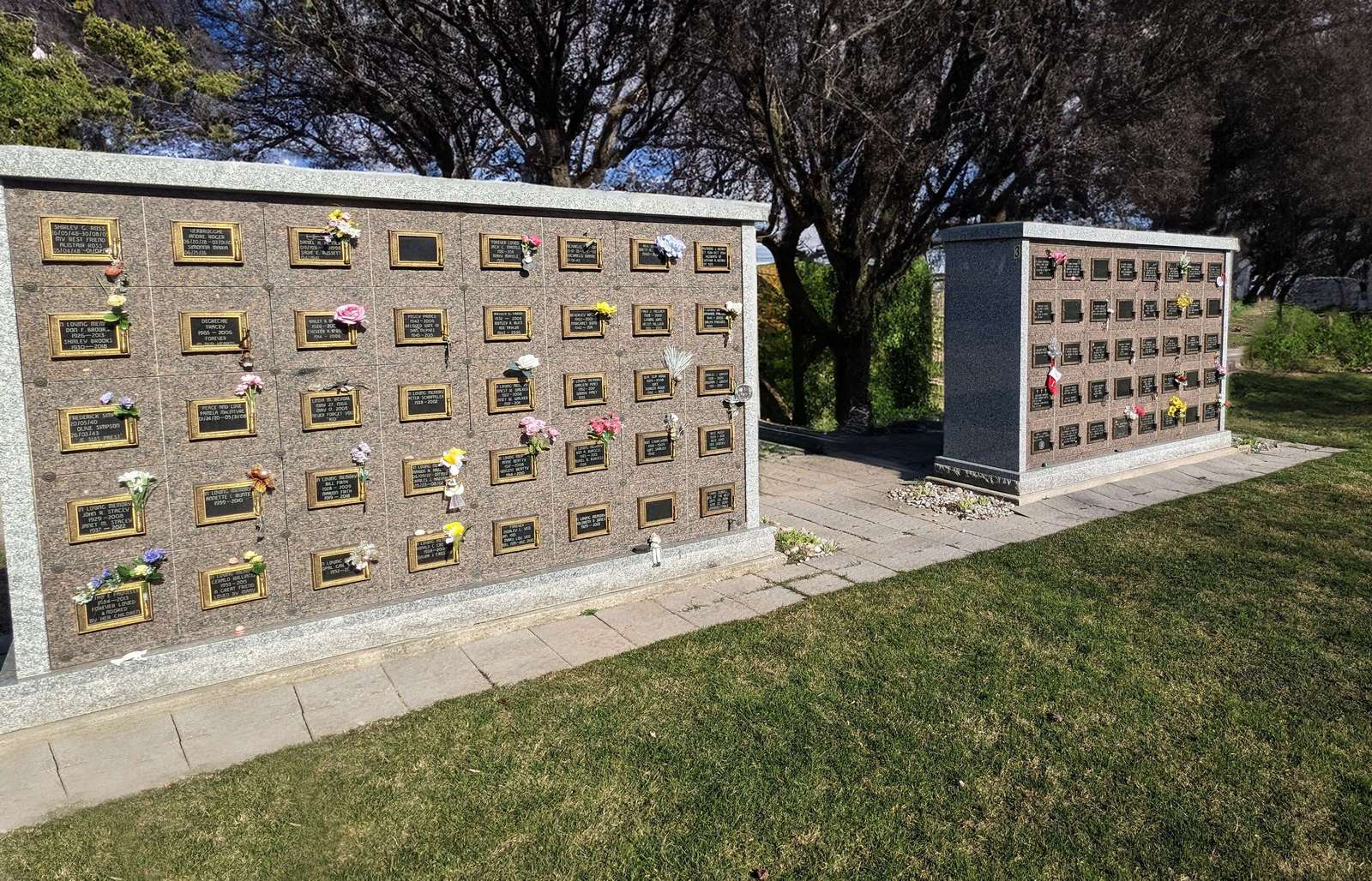 Two granite Kyber CC Chelmsford columbaria with integrated bronze plaques