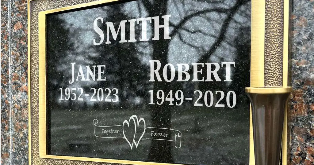 An engraved memorial plaque for an inurned married couple featuring a heart insignia