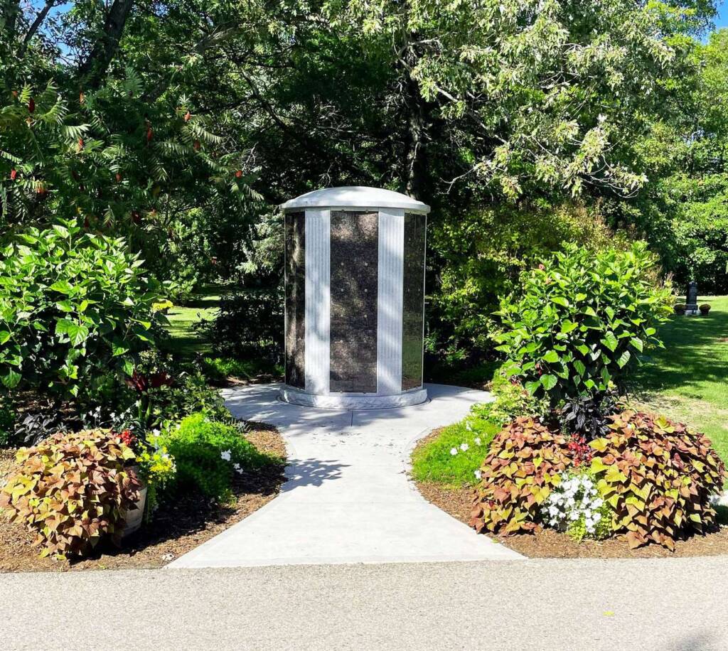 A round Windsor above-ground columbarium sits amidst lush greenery